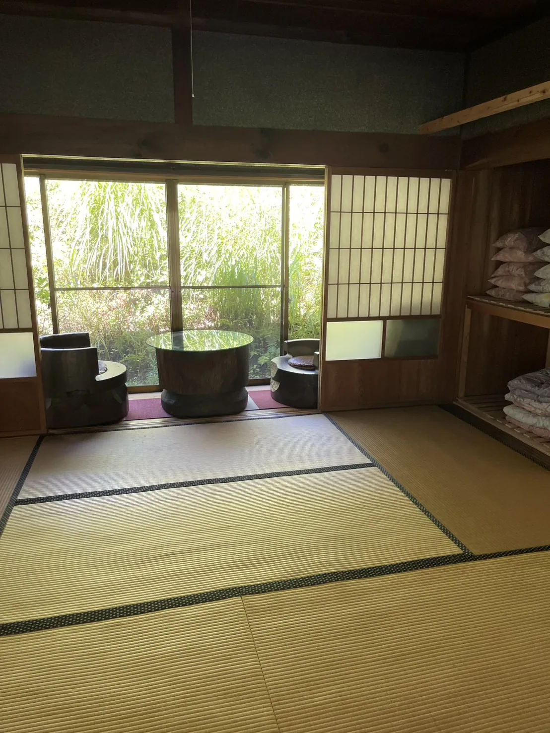 坪庭と手水鉢が見える和室。押入れに布団