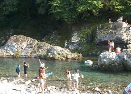岩場で川遊びをする家族